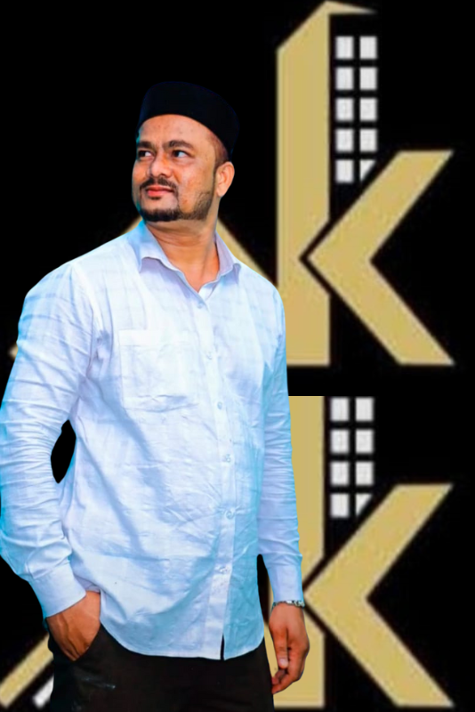 A confident man in a white shirt and black cap posing in front of the Akkhan Real Estate logo, representing professionalism in the real estate industry